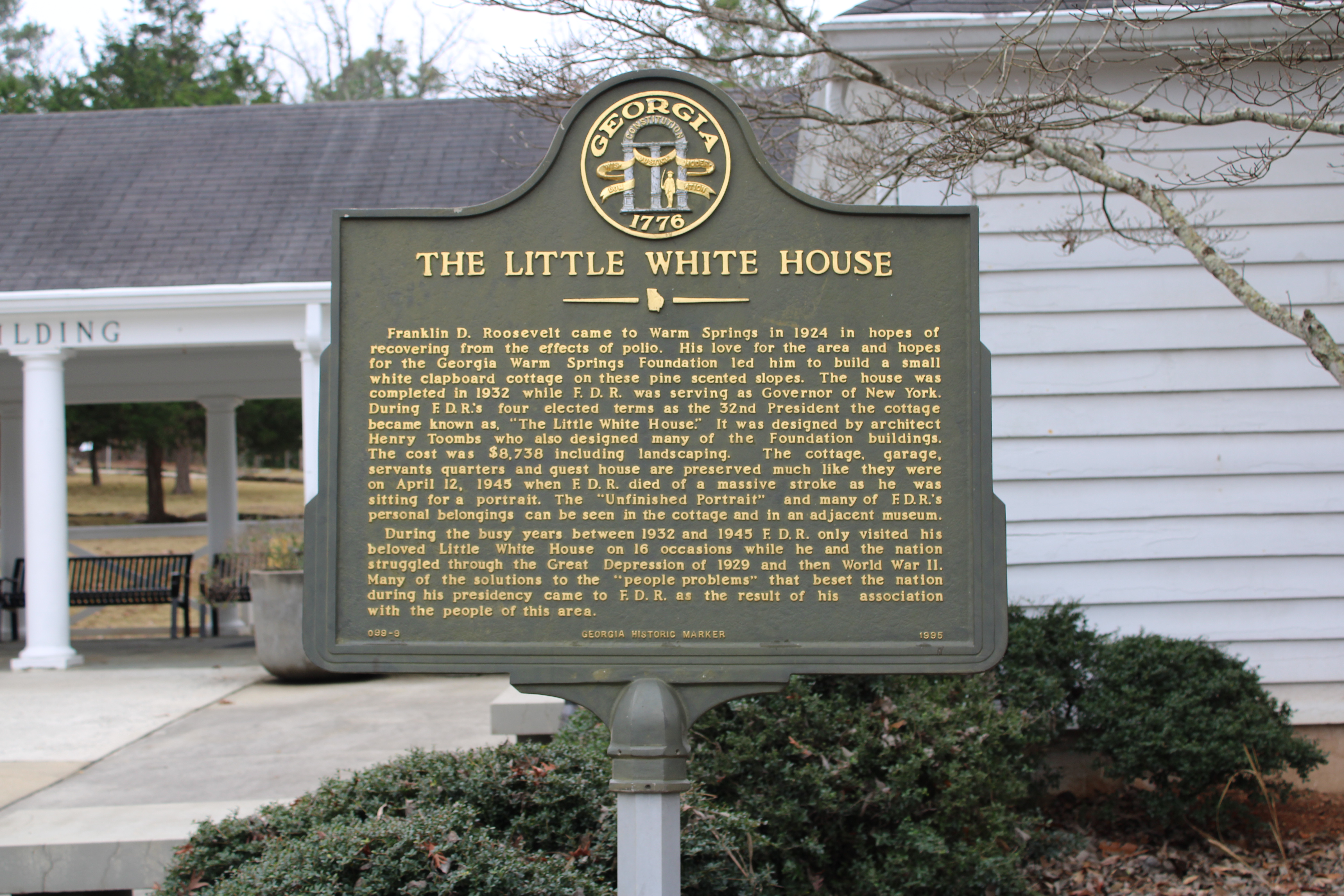 A Georgia Historical Marker which reads: Franklin D. Roosevelt came to Warm Springs in 1924 in hopes of recovering from the effects of Polio. His love for the area and hopes for the Georgia Warms Springs Foundation led to him to build a small white clapboard cottatge on these pine scented slopes. The house was completed in 1932 while FDR was serving as Governor of New York. During FDR's four elected terms as the 32nd President the cottage became known as The Little White House. It was designed by architect Henry Toombs who also designed many of the Foundation buildings. The cost was $8,738 including landscaping. The cottage, gargage, servants quarters and guest house are preserved much like they were on April 12, 1945 when FDR died of a massive stroke as he was sitting for a portrait. The unfinished portrait and many of FDR's personal belongings can be seen in the cottage and in an adjacent museum. During the busy years between 1932 and 1945 FDR only visited his beloved Little White House on 16 occasions while he and the nation struggled through the Great Depression of 1929 and then World War 2. Many of the solutions to the people problems that beset the nation during his presidency came to FDR as the result of his association with the people of this area.