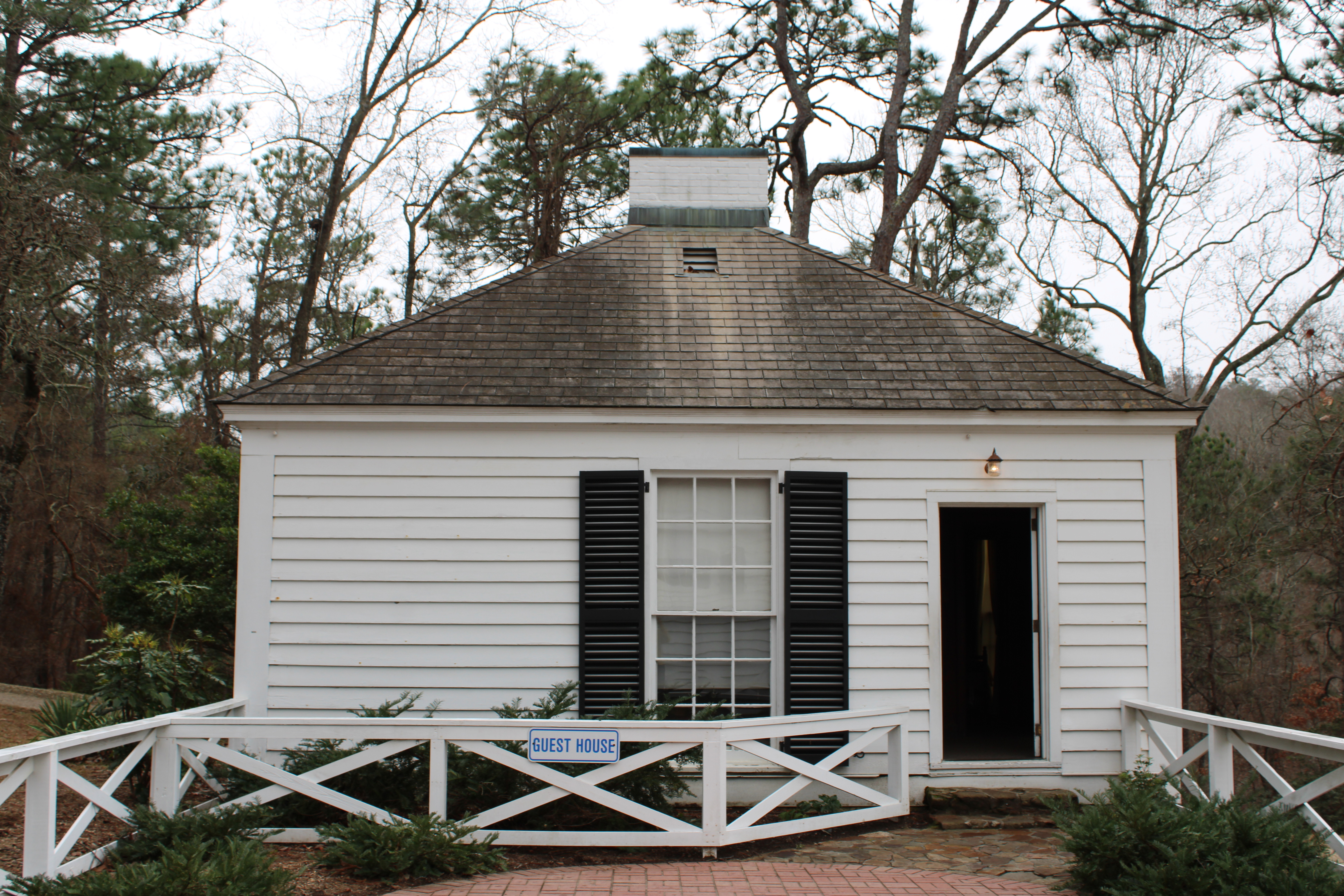The Guest house, a small white building with 1 door on the right and a window