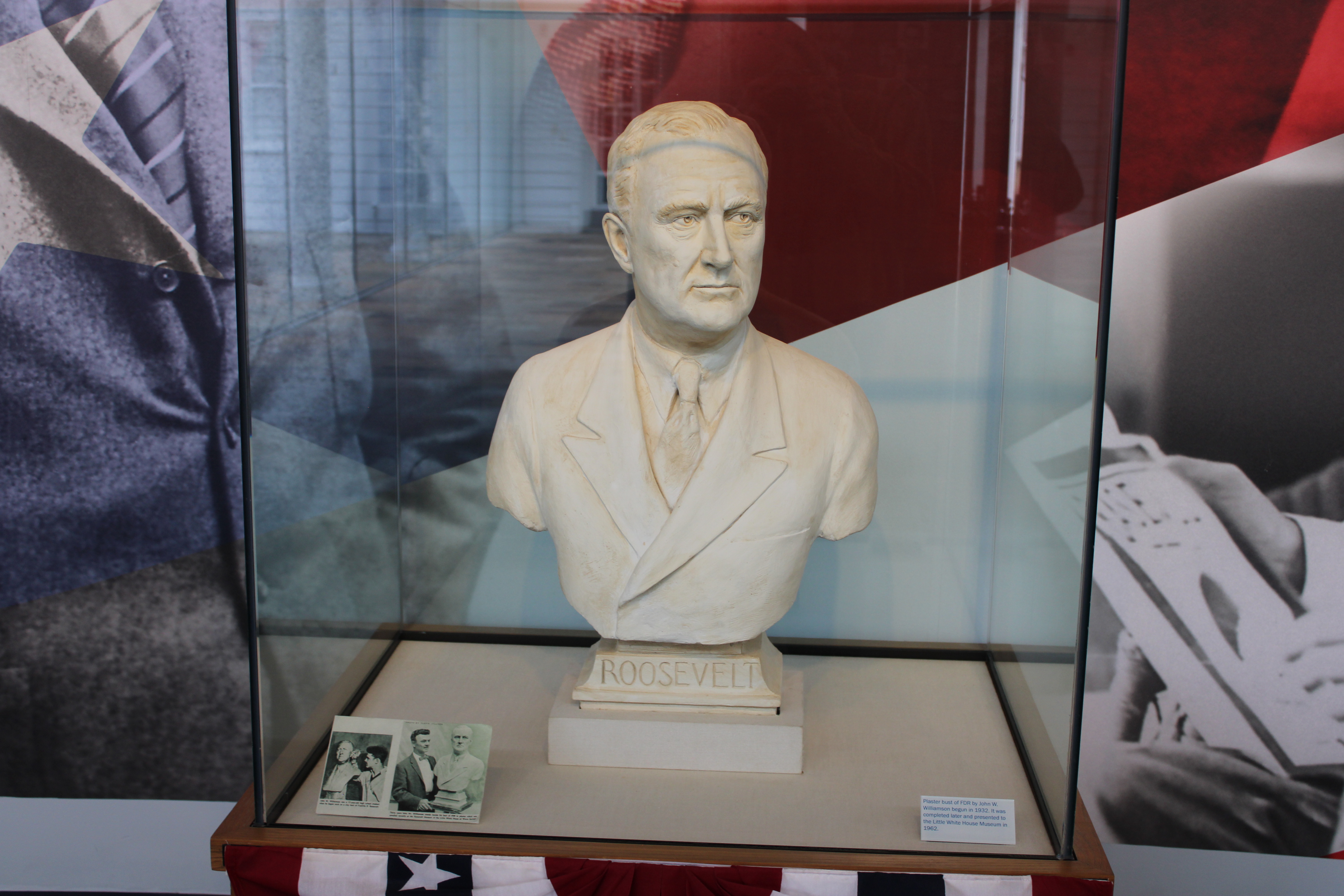 A marble bust of Franklin D Roosevelt encased in a glass cube.
